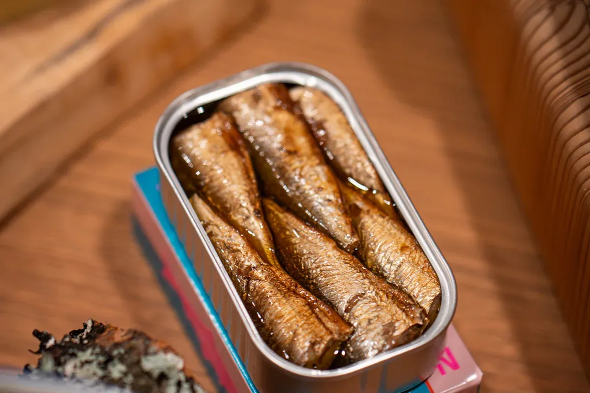 An open Nice Cans tin of sardines resting on its pink box at the launch tasting